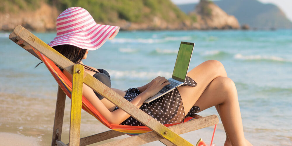 bleisure | woman on her laptop at the beach