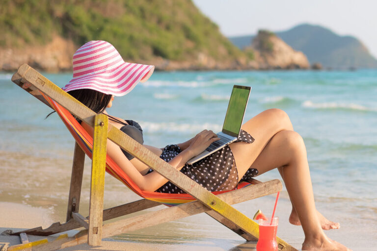 5056246-GI-1145636465-Woman-Working-Beach-1920×1080 bleisure | woman on her laptop at the beach
