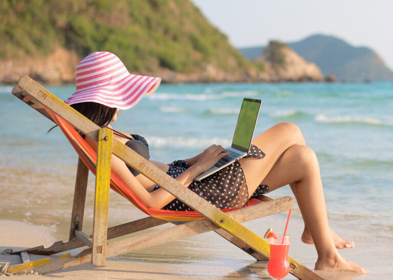bleisure | woman on her laptop at the beach